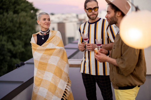 Friends have fun on a rooftop party at dusk - Photo, Image