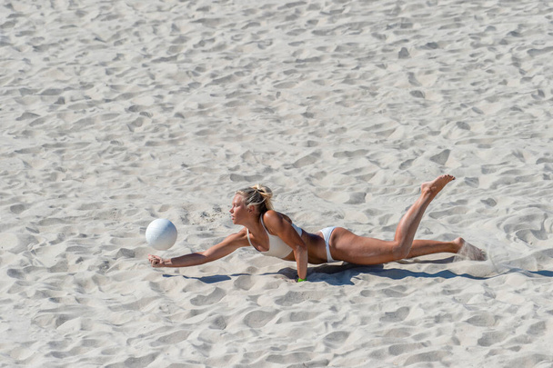 Νεαρή κοπέλα που παίζει βόλεϊ στην παραλία. Επαγγελματική έννοια του αθλητισμού - Φωτογραφία, εικόνα