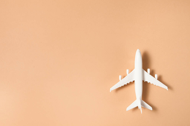 Flat lay design of travel concept with plane on brown background with place for text. - Foto, imagen