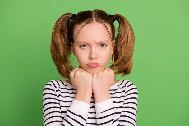 Photo of charming offended school girl wear white pullover fists arms chin isolated green color background - Foto, Imagem