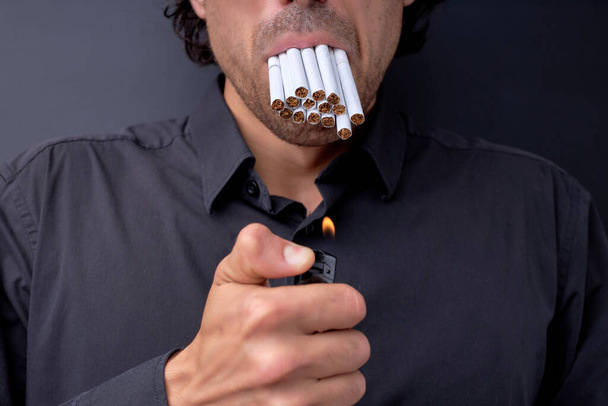 Cropped portrait of young handsome man with many cigarettes in mouth, quit smoking - Photo, Image