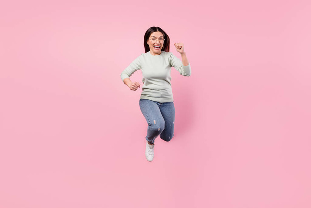 Full size photo of attractive excited happy lady jump up runner you isolated on pastel pink color background - Φωτογραφία, εικόνα