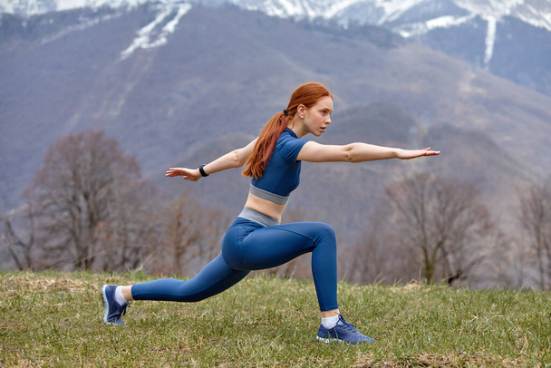 Fitness female in sports uniform makes lunge exercise to stretch legs muscles - Foto, Imagen