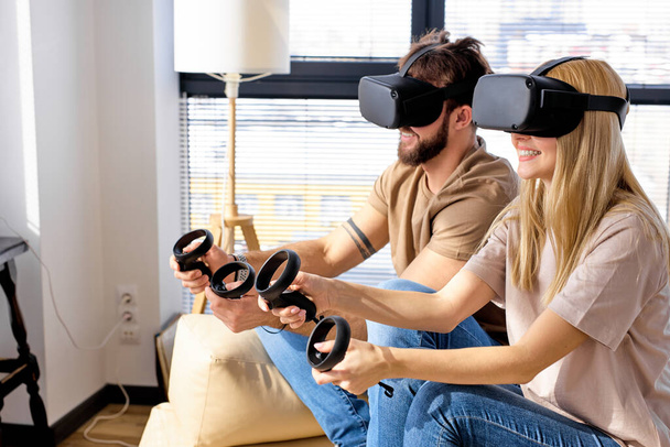 European couple, man and woman, having fun playing video console games together. - Fotografie, Obrázek