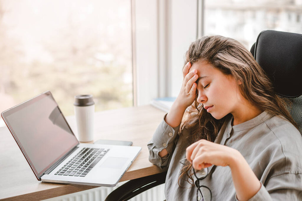 Müde und gestresste Geschäftsfrau sitzt mit Laptop im Home Office - Foto, Bild