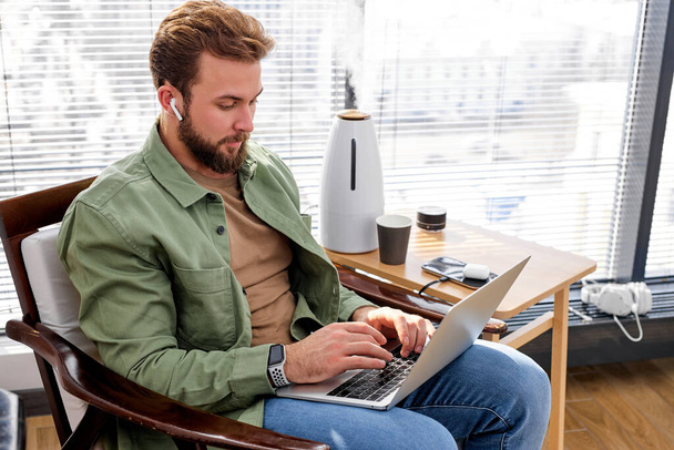 Confident caucasian male work holding laptop looking at computer screen, online learning - Foto, Bild