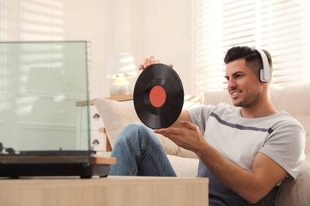 Happy man listening to music with turntable at home - Fotoğraf, Görsel