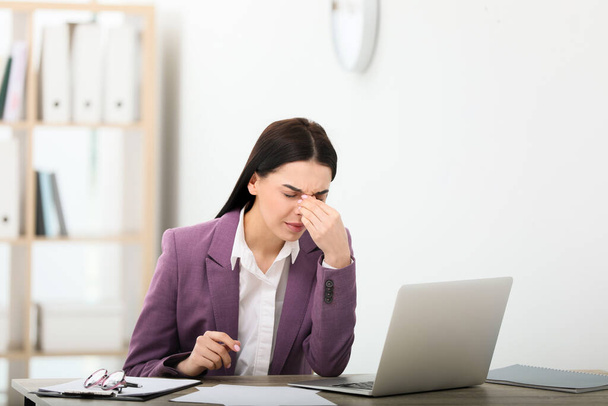 Woman suffering from migraine at workplace in office - Valokuva, kuva