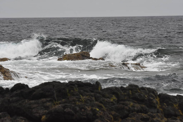 η θάλασσα στην ακτή με τα κύματα, τα σχήματα και τα χρώματα της - Φωτογραφία, εικόνα