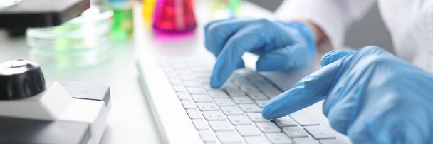 Scientist chemist typing on keyboard in laboratory closeup - Фото, зображення