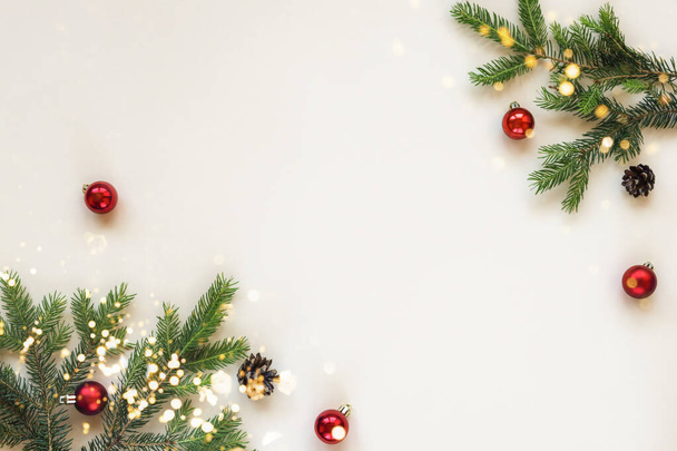 ベージュの背景にクリスマスのお祝いの背景モミの枝と赤いクリスマスボール。トップビュー、フラットレイアウト、コピースペース. - 写真・画像