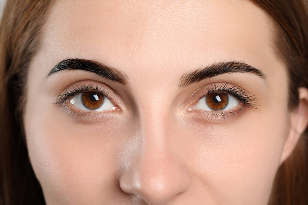 Woman during eyebrow tinting procedure, closeup view - Foto, imagen