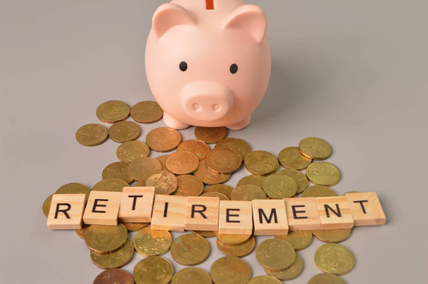 Piggy bank, stack of coins and alphabet letters with text RETIREMENT - Photo, Image