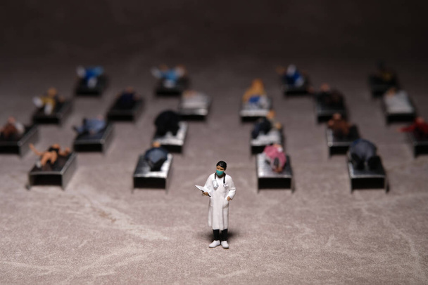 Miniature people toy figure photography. Full bed hospital occupancy rate concept. A doctor standing in front of patient. Image photo - Foto, Bild