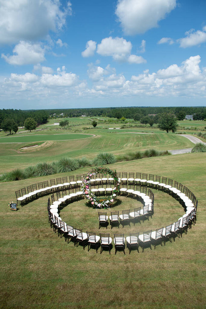 Unique round spiral chair pattern wedding ceremony setting at rolling hills estate above view - Foto, imagen
