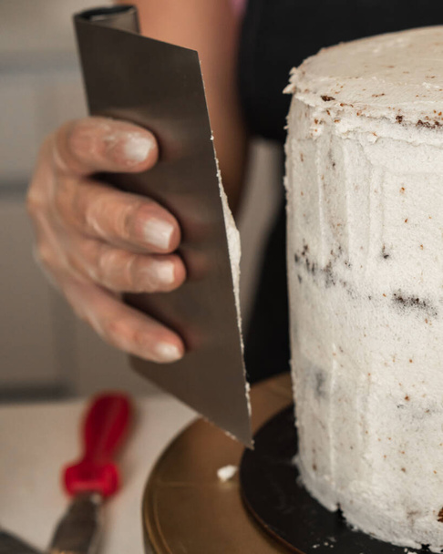 Close-up of a buttercream cake decoration with a large metal spatula - Foto, Bild