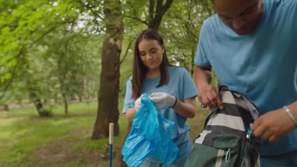 Multiethnic friends getting ready cleaning polluted forest area - Footage, Video