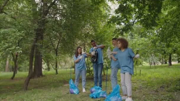 Team von Freiwilligen trinkt Wasser und genießt die Reinigung im Freien - Filmmaterial, Video