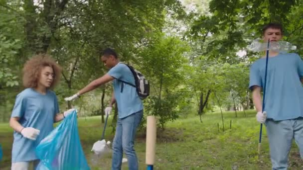 Ekologicky šetrný mladý muž vůdce dobrovolník dávat pokyny pro skupinu - Záběry, video