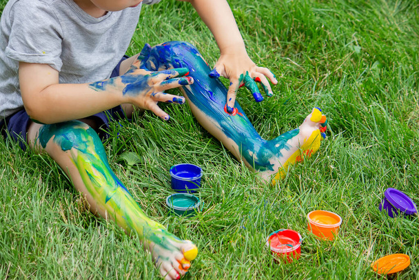 Дитина малює візерунок на нозі. Смішний малюнок з яскравими кольорами на тілі. Вибірковий фокус
 - Фото, зображення