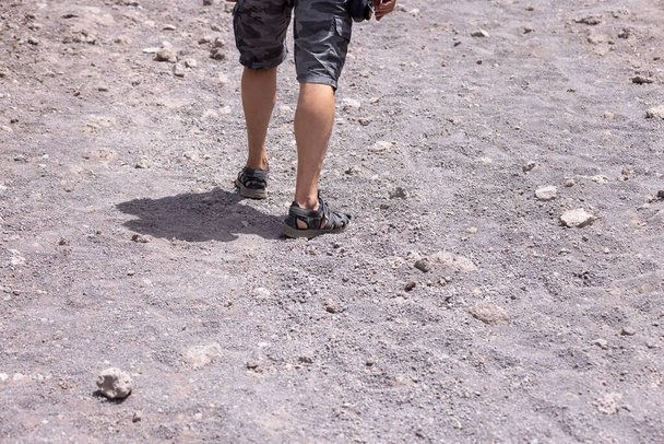 Turisti sandaaleissa kävelemässä polkua Vesuviuksen tulivuoren huipulle kuumana päivänä, Vesuvius vuori, Italia. Polku on tehty terävästä vulkaanisesta tufkasta. - Valokuva, kuva