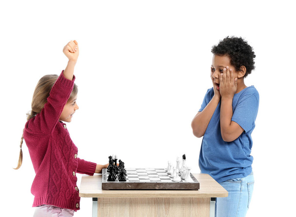 Niedliche kleine Kinder spielen Schach auf weißem Hintergrund - Foto, Bild