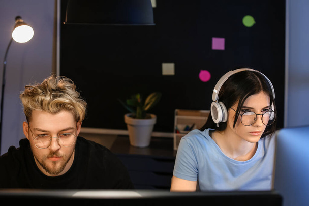 Young programmers working in office at night - Photo, Image