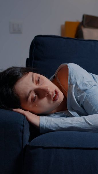 Δυστυχισμένη καταθλιπτική γυναίκα κλαίει ξαπλωμένη στον καναπέ και υποφέρει από αϋπνία - Φωτογραφία, εικόνα