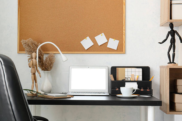 Posto di lavoro moderno con laptop vicino alla parete luminosa - Foto, immagini