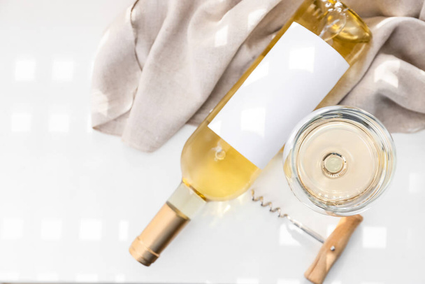 Láhev a sklenice vynikajícího vína na lehkém stolku - Fotografie, Obrázek