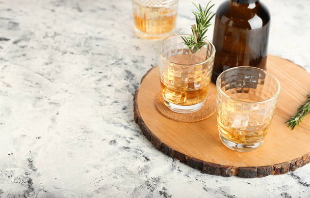 Botella y vasos de whisky frío sobre fondo claro - Foto, Imagen