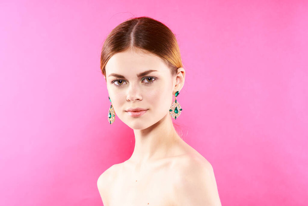 attractive woman earrings bare shoulders decoration Glamor pink background - Foto, imagen