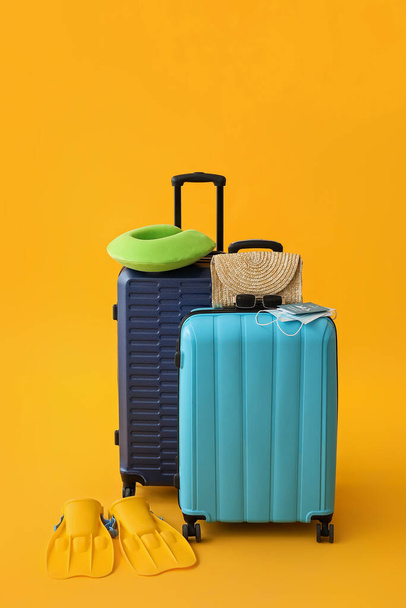 Packed suitcases with immune passport, medical masks and travel accessories on color background - Foto, Bild