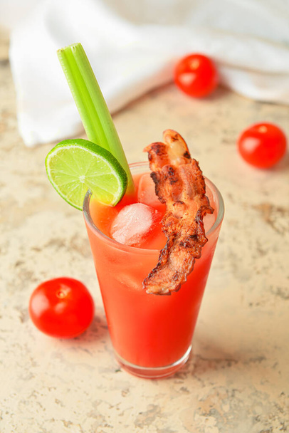 Glass of bloody mary cocktail garnished with bacon on grunge background - Photo, image