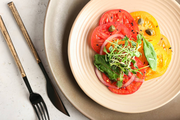Πιάτο με νόστιμο καρπάτσιο ντομάτας και μαχαιροπήρουνα σε ελαφρύ φόντο, closeup - Φωτογραφία, εικόνα