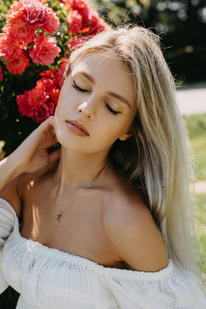 Closeup portrait of a young blonde woman with closed eyes, outdoors. - Foto, immagini