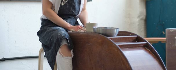 Женщина-Поттер создает глиняную банку на гончарном круге - Фото, изображение