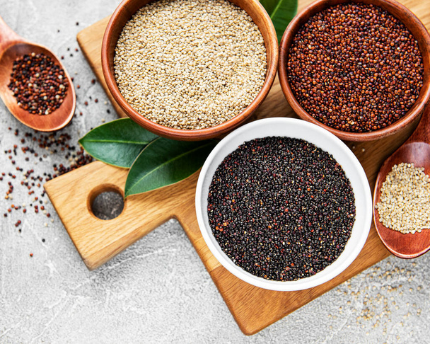 Red, black and white quinoa seeds on a concrete background - Fotó, kép