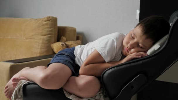 poika nukkuu suloisesti tietokoneen tuolilla - Materiaali, video