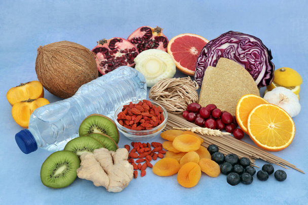 Diet detox health food collection high in fibre, vitamins, minerals, antioxidants & anthocyanins. Spring water, vegetables, fruit, spice, herbs, wholegrain foods & oatmeal crackers. On mottled blue. - Photo, Image