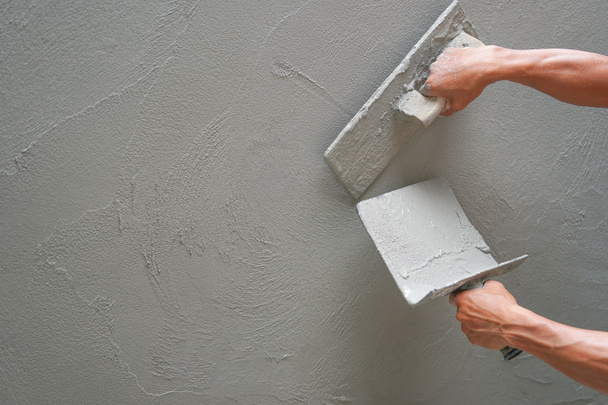 mano del trabajador enlucido muro de cemento en el sitio de construcción con espacio de copia, enfoque selectivo                              - Foto, Imagen