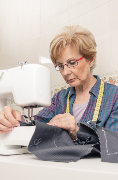 Senion donna cucitrice che lavora sulla macchina da cucire
 - Foto, immagini