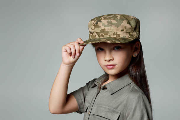 child girl wear military uniform. kid dressed like a soldier - Foto, afbeelding