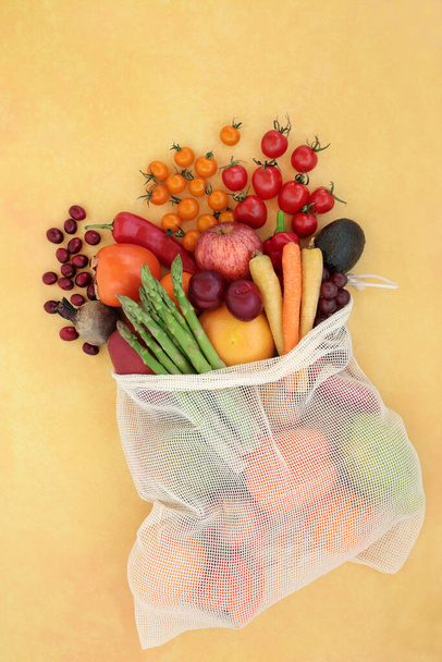 Egészséges gyümölcs és zöldség egy nettó bevásárló zsák magas likopin az egészséges szív & csökkenti a vérnyomást is magas antioxidánsok, antocianinok, vitaminok, ásványi anyagok és élelmi rost. Lapos feküdt foltos sárga. - Fotó, kép