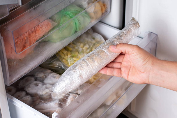 Man takes out frozen fish from the freezer. Frozen fish. Frozen food - Photo, Image