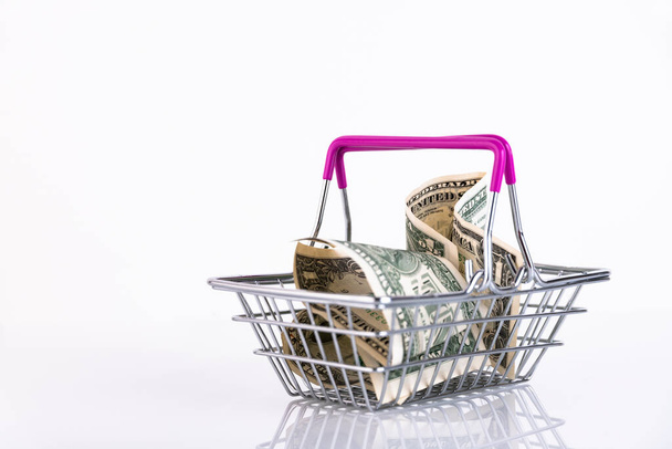 Shopping basket and US dollars on a white background. Copy space. - Фото, зображення