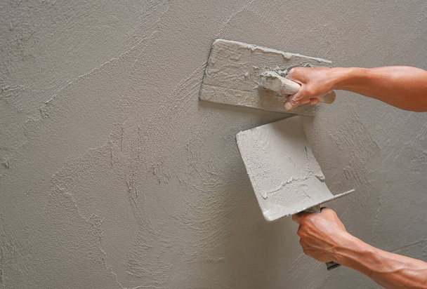 mão do trabalhador reboco parede de cimento no canteiro de obras com espaço de cópia, foco seletivo                                                                                  - Foto, Imagem