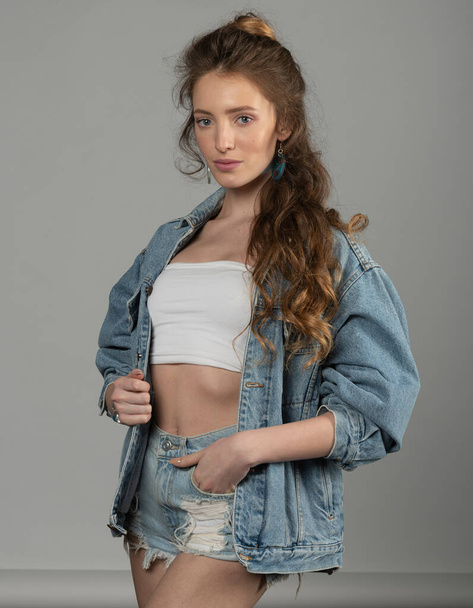 pretty woman in outfit dress , she is posing and looking in camera with shorts and jacket jeans - Foto, imagen