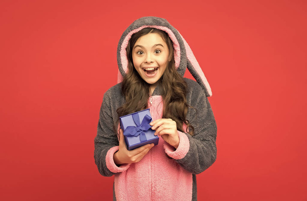 happy teenage girl wear funny rabbit kigurumi pajamas and hold gift box, black friday - Foto, afbeelding