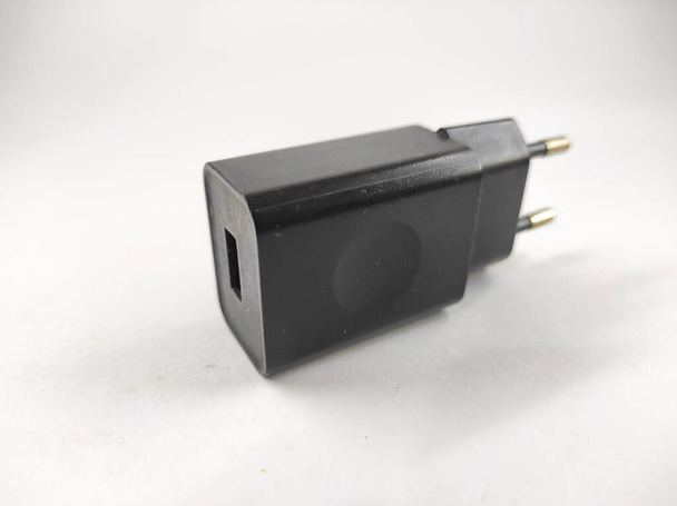 черный смартфон зарядное устройство голову изолированы на белом фоне в мини-студии - Фото, изображение